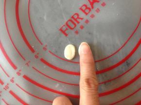 揪出两小块面团，用食指压一下，成椭圆形，做眼睛