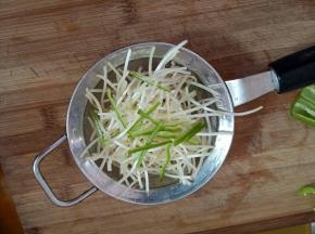 再把豆芽和青椒放入漏勺中。