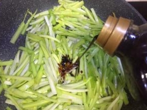 再放入韭黄叶铺在上面倒入两勺生抽，炒拌均匀七成熟，关火