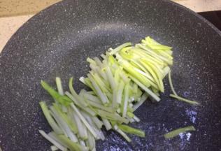 平底锅放入食用油，油温八成放入韭黄径翻炒