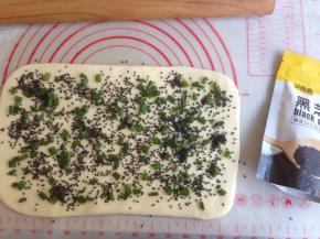 葱粒加点盐混合后铺在面片上，再撒些黑芝麻