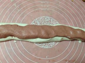 先将白色的面团捏成长条，再将红色面团也捏成长条，两种面条面团并在一起压扁