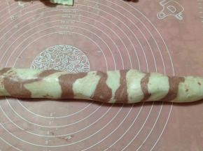 先慢慢转动面团，再轻轻揉搓面团，使两种颜色的面团略微混合在一起(不要揉得太厉害，如果两种颜色的面团充分融合了，就没有清晰的花纹了)。