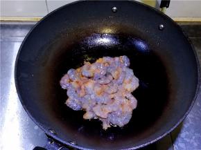 锅中再放入适量的油，倒入腌制好的虾仁。