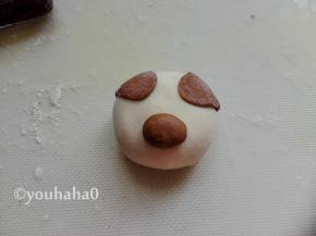 圆形的面团刷一点点水，粘在豆沙包的中下部，作为小猪的鼻子