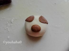 圆形的面团刷一点点水，粘在豆沙包的中下部，作为小猪的鼻子