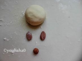 包好的豆沙包稍微压扁一点，取一点面团揉入少许的可可粉，可可面团分出3的小面剂子，2个擀成椭圆形，一个捏成圆形