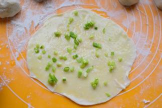 先在面片上刷一层油，再撒少许盐，最后撒上葱花