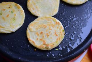 电饼铛预热，中大火，多放些油，锅热起来再把饼胚放在电饼铛上，一面烙金黄翻面，直到两面都变金黄即可