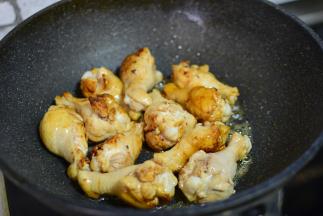 锅中加油，加白糖，熬至白糖变成咖啡色，加入煮过的小鸡腿，炒匀至鸡腿上色