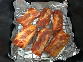 把腌好的肋排铺在烤架上。