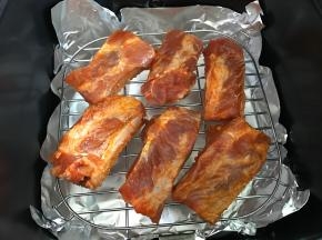 把腌好的肋排铺在烤架上。