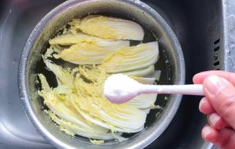 把切开的黄芽菜放入装有清水的盆里，加入一勺盐，浸泡一会儿