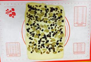 铺上干果，其中一边留2～3厘米左右不放三果，留做封边粘合。 核桃仁的大小不宜太大，太大了卷的不紧，我用的核桃仁大小是核桃的四分之一大小。