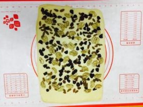 铺上干果，其中一边留2～3厘米左右不放三果，留做封边粘合。 核桃仁的大小不宜太大，太大了卷的不紧，我用的核桃仁大小是核桃的四分之一大小。