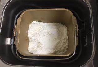 然后放入粉类，盐和糖对角放，酵母放中间，用面粉盖上。启动面包机和面功能，开始工作。