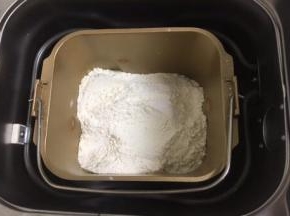 然后放入粉类，盐和糖对角放，酵母放中间，用面粉盖上。启动面包机和面功能，开始工作。
