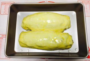 把发酵好的大面包的表面刷上全蛋液。