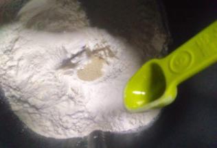 把材料除了黄油外，都放入面包桶，顺序为牛奶、鸡蛋、糖和盐对角放，然后放面粉，面粉挖个洞放入酵母