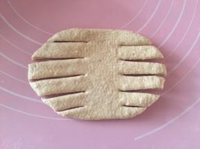 松弛下来的面团，取一个擀成横的椭圆形，两边割成6条