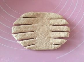 松弛下来的面团，取一个擀成横的椭圆形，两边割成6条