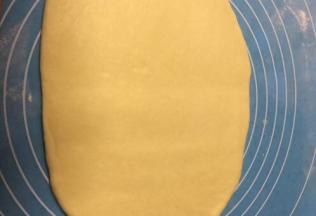 醒好的面用擀面杖擀成椭圆形