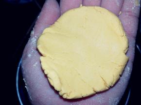 取一块面团，在掌心按扁。