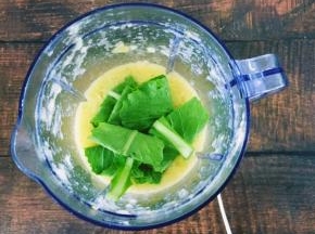 搅拌后将青菜一片片折起来放入