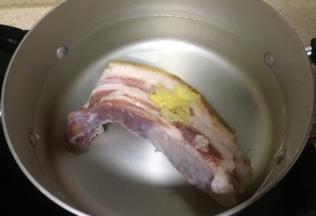菜市场买回新鲜五花肉已烧皮去毛洗净，锅里加入清水和老姜，煮五花肉
