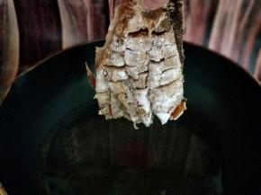 这样，首先拎着鱼尾巴，将热油用勺子往鱼身上淋，这样鱼更容易定型。