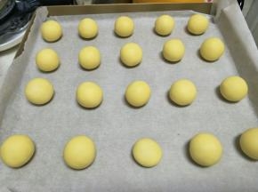 之后，分割成9克一个的面团，搓成小球。摆入烤盘。
