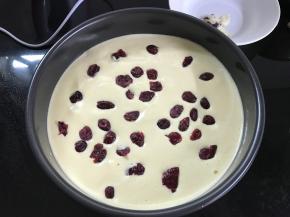 将翻拌好的米糊倒入8寸蛋糕模，震出大气泡后面糊上再铺上一层蔓越莓干。