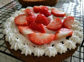 奶油放入裱花袋，挤到一片蛋糕片上，摆入切好的草莓。