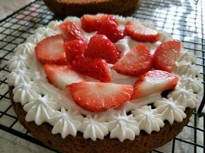 奶油放入裱花袋，挤到一片蛋糕片上，摆入切好的草莓。