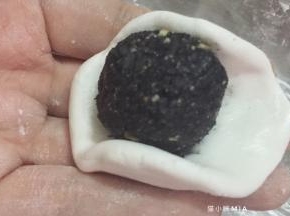 将面团剂子轻轻按压成小碗状，一份面团包住一份内馅，依次包好所有的汤圆，并揉圆，最后滚一圈糯米粉防粘