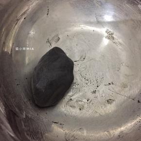 将剩下的白面团加入适量黑炭粉，如果此时面团有点干，可以倒入少许开水，最后揉成黑色的面团