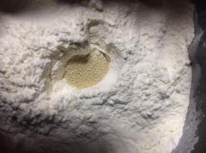 把面粉掏个洞放入发酵粉，再盖上