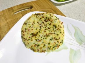 煎好的米饭饼扣在盘子里，再煎另外一片。