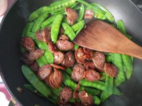 放入腊肠，翻炒。