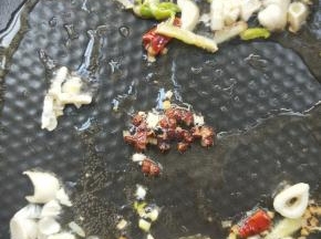 放花椒粒煸炒出香味。