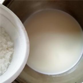 将过了筛的杏仁浆倒入锅中，加入适量的糖，中小火加热。