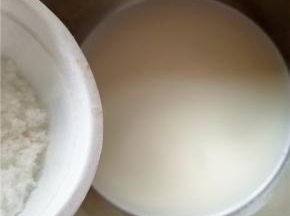 将过了筛的杏仁浆倒入锅中，加入适量的糖，中小火加热。