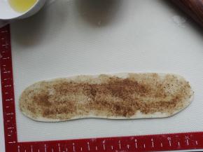 醒发后的面团压扁、擀长，面团上先抹一层植物油，薄薄的一层，勿多，再抹上椒盐