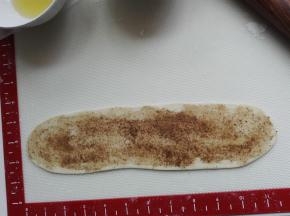 醒发后的面团压扁、擀长，面团上先抹一层植物油，薄薄的一层，勿多，再抹上椒盐