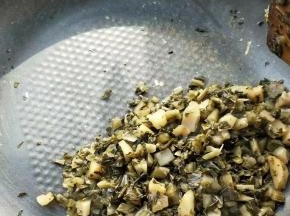 焙干到图这样，锅中腌菜没水分了，就可以用铲子拨到锅一边。