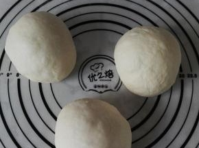 取出发酵后的面团，按压排气，分割为均等的3份，滚圆，盖保鲜膜醒发20分钟