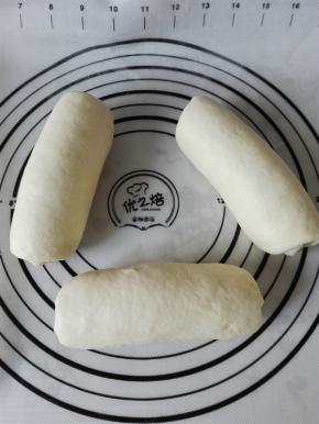 取一个醒发后的面团按扁、翻面、上下擀长，自上而下卷起，依次做完3个面团，盖保鲜膜继续醒发20分钟