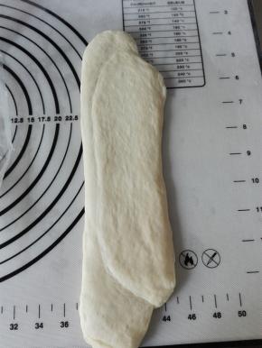 取一个醒发后的面团，接口朝上、上下擀长