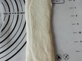 取一个醒发后的面团，接口朝上、上下擀长