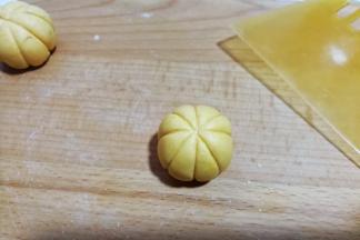 然后用刮板呈“米”字形，在糯米团上压出南瓜形花纹（操作时左手拿糯米团，右手拿刮板从上往下轻轻推挤着压出花纹，一个人拍照不好拍出此步骤细节）